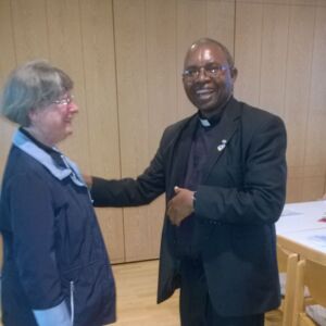 Father Pastor Mpora begrüßt herzlich eine Teilnehmerin beim Treffen im Juni 2017 in München