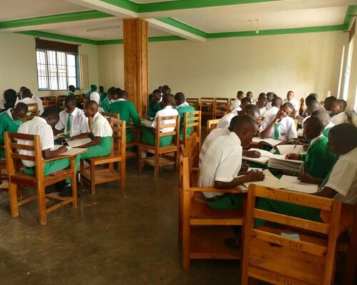 Schülerinnen und Schüler lernen in Gruppen an Tischen im Klassenzimmer